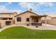 Backyard with artificial turf, desert landscaping and covered patio with string lights at 11163 E Laurel Ln, Scottsdale, AZ 85259