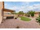 Spacious backyard with artificial turf, desert landscaping, and a covered patio at 11163 E Laurel Ln, Scottsdale, AZ 85259