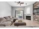 Comfortable living room with a ceiling fan, fireplace, backyard view, and a large sectional for relaxation at 11163 E Laurel Ln, Scottsdale, AZ 85259