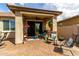Covered back patio with colorful chairs, outdoor furniture, ceiling fan, and brick flooring at 11571 E Chevelon Trl, Gold Canyon, AZ 85118