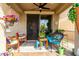 Cozy covered back patio with colorful patio furniture, hanging plants, and ceiling fan at 11571 E Chevelon Trl, Gold Canyon, AZ 85118