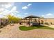 Landscaped backyard featuring a gazebo, patio furniture, manicured lawn, and brick pavers at 11571 E Chevelon Trl, Gold Canyon, AZ 85118