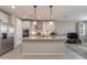 Modern kitchen with large island, pendant lights, stainless steel appliances, and white cabinets at 11738 S 173Rd Ln, Goodyear, AZ 85338