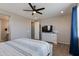 Cozy main bedroom with ceiling fan, TV, and a view to the ensuite bathroom at 11738 S 173Rd Ln, Goodyear, AZ 85338