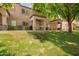 Exterior of home featuring a covered patio, lush green lawn, and mature shade tree at 125 S 56Th St # 100, Mesa, AZ 85206