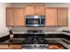 Kitchen features new range and microwave, dark countertops and oak cabinets at 125 S 56Th St # 100, Mesa, AZ 85206