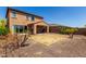 Backyard with desert landscaping, covered patio, and tile roof at 13749 W Amberwing St, Peoria, AZ 85383