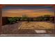 Secluded backyard featuring desert landscaping, rock ground cover, mature trees, and block fence providing privacy at 13749 W Amberwing St, Peoria, AZ 85383