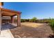 Open backyard with desert landscaping, gravel, and covered patio area at 13749 W Amberwing St, Peoria, AZ 85383