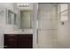 This bathroom has a long vanity with a large mirror and a white shower at 13749 W Amberwing St, Peoria, AZ 85383