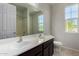 Bathroom with double vanity and a mirror reflecting the shower and windows at 13749 W Amberwing St, Peoria, AZ 85383