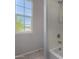 Bathroom featuring a window and a bathtub-shower combo at 13749 W Amberwing St, Peoria, AZ 85383