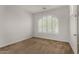 Bright bedroom featuring an arched window with white shutters and neutral carpeting at 13749 W Amberwing St, Peoria, AZ 85383