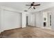 Spacious bedroom with ceiling fan, neutral carpet and view to ensuite and walk in closet at 13749 W Amberwing St, Peoria, AZ 85383