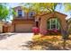 Charming two-story home featuring a well-manicured front yard and a two car garage at 13749 W Amberwing St, Peoria, AZ 85383