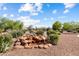 Rock waterfall feature in the desert-landscaped backyard of a single-Gathering home at 13841 W Nogales Dr, Sun City West, AZ 85375