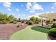 Spacious backyard features desert landscaping, a rock waterfall, and a putting green at 13841 W Nogales Dr, Sun City West, AZ 85375