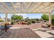 A covered patio leads to a sprawling backyard with desert landscaping and a rock waterfall feature at 13841 W Nogales Dr, Sun City West, AZ 85375