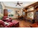 Home office with built in shelving, hardwood floors, ceiling fan, and comfortable seating at 13841 W Nogales Dr, Sun City West, AZ 85375