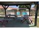 Community pool surrounded by picnic tables and lush landscaping, perfect for relaxing outdoors at 141 N Date -- # 7, Mesa, AZ 85201