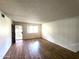 Bright living room featuring wood-look flooring, a front-facing window, and an entry door for easy access at 141 N Date -- # 7, Mesa, AZ 85201