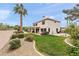 Expansive backyard with a lush lawn, desert landscaping, mature palm tree, and outdoor living spaces at 1515 E Saratoga Ct, Gilbert, AZ 85296
