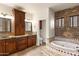 Luxurious bathroom with a jacuzzi tub, stone wall, mosaic tile floors, and dual sink vanity at 1515 E Saratoga Ct, Gilbert, AZ 85296