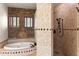 Luxurious bathroom features a jetted tub with stone accent wall and stone-tiled shower with black fixtures at 1515 E Saratoga Ct, Gilbert, AZ 85296