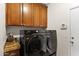 Practical laundry room includes cabinets and modern, efficient, black front-loading washer and dryer at 1515 E Saratoga Ct, Gilbert, AZ 85296