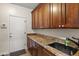 Functional laundry room features granite countertops and cabinets providing ample storage and workspace at 1515 E Saratoga Ct, Gilbert, AZ 85296