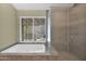 Bathroom featuring a soaking tub with window and glass-enclosed shower at 1617 E Fremont Rd, Phoenix, AZ 85042