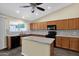 Sunlit kitchen with a central island, wood cabinets, updated appliances, and modern backsplash at 1617 E Fremont Rd, Phoenix, AZ 85042