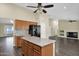 Open kitchen featuring an island, stainless steel appliances, wood cabinets, and modern backsplash at 1617 E Fremont Rd, Phoenix, AZ 85042
