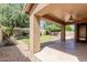 Covered patio flows out to the backyard with grass, landscaping, and sitting area at 16228 W Crocus Dr, Surprise, AZ 85379