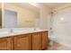 Bathroom featuring a double sink vanity with wood cabinets and a shower-tub combination at 16228 W Crocus Dr, Surprise, AZ 85379