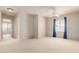 Spacious bedroom featuring plush carpet, a ceiling fan, and large windows with blue curtains at 16228 W Crocus Dr, Surprise, AZ 85379