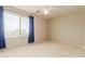 Cozy bedroom with carpet flooring, a ceiling fan, and large window with blue curtains at 16228 W Crocus Dr, Surprise, AZ 85379