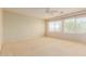 Bright bedroom featuring carpet, large windows, and neutral walls at 16228 W Crocus Dr, Surprise, AZ 85379
