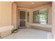 A covered front porch with a security screen door, with desert landscaping and large windows at 16228 W Crocus Dr, Surprise, AZ 85379