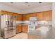 Bright kitchen featuring stainless steel refrigerator and range, with ample cabinet and counter space at 16228 W Crocus Dr, Surprise, AZ 85379
