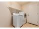 Laundry room with side by side washer and dryer with overhead shelving at 16228 W Crocus Dr, Surprise, AZ 85379