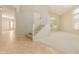 Spacious living room featuring tile and carpet flooring, staircase, and large bright windows at 16228 W Crocus Dr, Surprise, AZ 85379