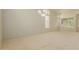 Large, bright, carpeted living room with many windows and neutral paint at 16228 W Crocus Dr, Surprise, AZ 85379