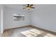 Bright bedroom featuring wood-look flooring, a ceiling fan, and a window for natural light at 17812 N Carmen Ave, Maricopa, AZ 85139