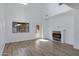 Open living area features an electric fireplace, high ceilings, and a glass door leading outside at 17812 N Carmen Ave, Maricopa, AZ 85139