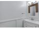 Stylish powder room features a wood-trimmed mirror and a white vanity with modern fixtures at 17812 N Carmen Ave, Maricopa, AZ 85139