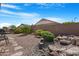 Backyard featuring decorative rock, flagstone path, privacy wall, and desert landscaping at 18163 W Addie Ln, Surprise, AZ 85374