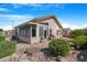Landscaped backyard with a covered patio, a well-manicured lawn, and mature trees at 18163 W Addie Ln, Surprise, AZ 85374