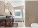 Luxurious bathroom boasting dual sinks, a large soaking tub, a glass-enclosed shower, and tile flooring at 18163 W Addie Ln, Surprise, AZ 85374