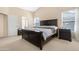 Spacious primary bedroom featuring neutral carpeting, a large bed and bedside tables, and plenty of natural light at 18163 W Addie Ln, Surprise, AZ 85374